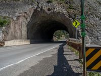 a road goes into a tunnel and through the hill to the other side of it