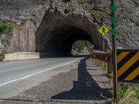 a road goes into a tunnel and through the hill to the other side of it