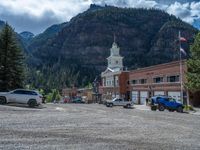 a big house with two fire trucks parked next to it and mountains in the background