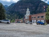 a big house with two fire trucks parked next to it and mountains in the background