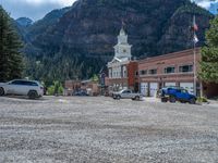 a big house with two fire trucks parked next to it and mountains in the background