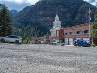 a big house with two fire trucks parked next to it and mountains in the background