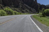 the road is empty for traffic as the motorcycle rides along it's course in the mountains