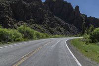 the road is empty for traffic as the motorcycle rides along it's course in the mountains