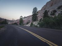 an empty road near the mountains on a clear day at sunset with sunlight casting shadows