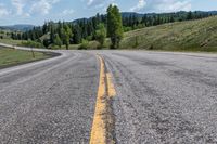 the empty highway has a single yellow line on it as it winds along the road