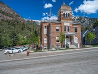 a big house with two fire trucks parked next to it and mountains in the background