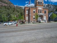 a big house with two fire trucks parked next to it and mountains in the background