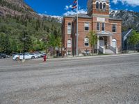 a big house with two fire trucks parked next to it and mountains in the background