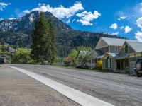 a big house with two fire trucks parked next to it and mountains in the background