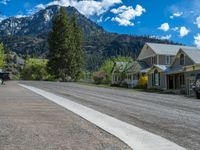 a big house with two fire trucks parked next to it and mountains in the background