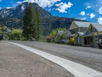 a big house with two fire trucks parked next to it and mountains in the background