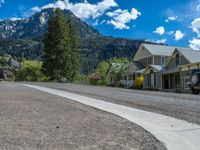 a big house with two fire trucks parked next to it and mountains in the background