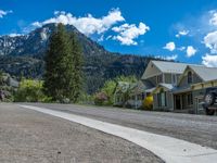 a big house with two fire trucks parked next to it and mountains in the background