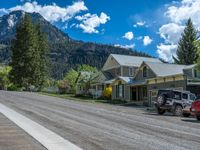 a big house with two fire trucks parked next to it and mountains in the background