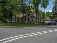 a road and trees line a residential street in a residential area in a neighborhood with no parking