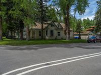 a road and trees line a residential street in a residential area in a neighborhood with no parking