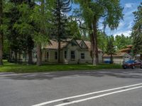 a road and trees line a residential street in a residential area in a neighborhood with no parking