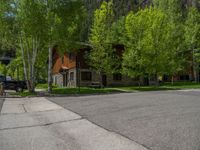 an empty street lined with trees and a mountain range in the distance in the back