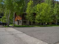 an empty street lined with trees and a mountain range in the distance in the back