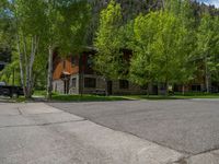 an empty street lined with trees and a mountain range in the distance in the back