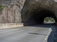 a road goes into a tunnel and through the hill to the other side of it