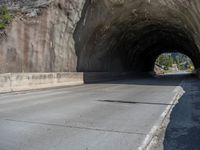 a road goes into a tunnel and through the hill to the other side of it