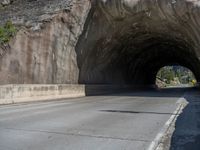 a road goes into a tunnel and through the hill to the other side of it