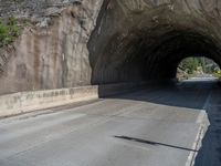 a road goes into a tunnel and through the hill to the other side of it