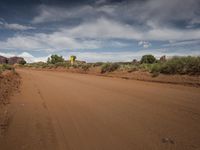 a road in a desert with a yellow and white sign on the side of it