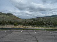 a mountain sits in the distance in a parking lot with a few trees and shrubbery