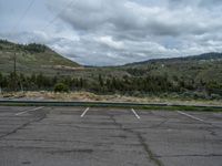 a mountain sits in the distance in a parking lot with a few trees and shrubbery