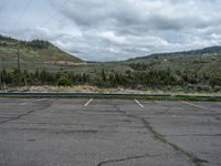 a mountain sits in the distance in a parking lot with a few trees and shrubbery