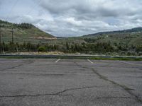 a mountain sits in the distance in a parking lot with a few trees and shrubbery