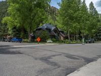 an empty street lined with trees and a mountain range in the distance in the back