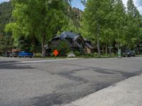 an empty street lined with trees and a mountain range in the distance in the back