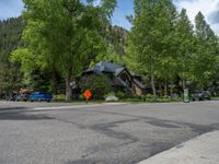 an empty street lined with trees and a mountain range in the distance in the back