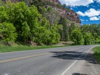 the red rocks are high up on the side of the road and it is an amazing color