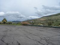 a mountain sits in the distance in a parking lot with a few trees and shrubbery