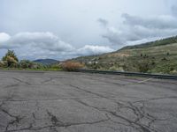 a mountain sits in the distance in a parking lot with a few trees and shrubbery