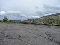 a mountain sits in the distance in a parking lot with a few trees and shrubbery