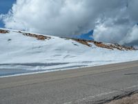 the man is at the top of a mountain on skis with mountains in the background