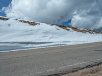 the man is at the top of a mountain on skis with mountains in the background