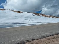 the man is at the top of a mountain on skis with mountains in the background