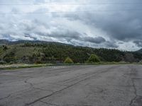 a mountain sits in the distance in a parking lot with a few trees and shrubbery