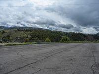 a mountain sits in the distance in a parking lot with a few trees and shrubbery