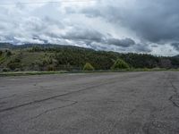 a mountain sits in the distance in a parking lot with a few trees and shrubbery