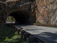 a road goes into a tunnel and through the hill to the other side of it