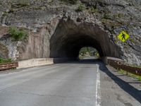 a road goes into a tunnel and through the hill to the other side of it