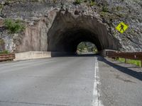 a road goes into a tunnel and through the hill to the other side of it